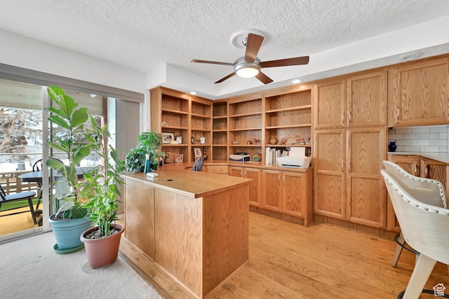 home office featuring a ceiling fan, a textured ceiling, and light wood-style flooring
