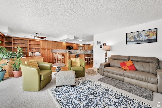 living area featuring a textured ceiling and a ceiling fan
