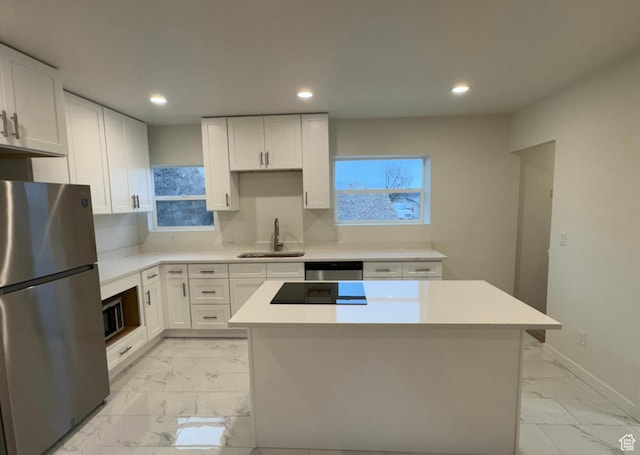 kitchen featuring marble finish floor, white cabinetry, stainless steel appliances, and light countertops