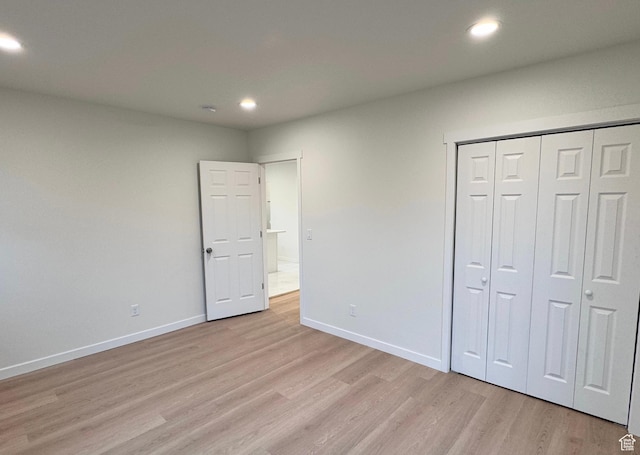 unfurnished bedroom with recessed lighting, a closet, baseboards, and light wood finished floors