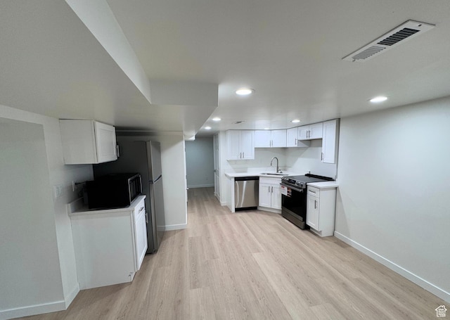 kitchen with stainless steel appliances, white cabinets, light countertops, and visible vents