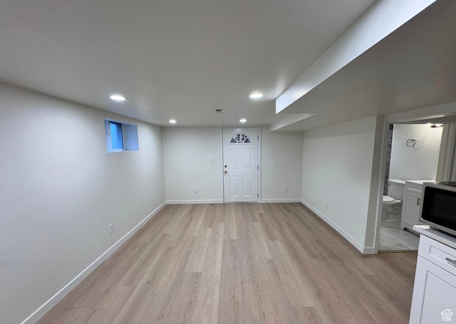 finished below grade area featuring recessed lighting, light wood-style flooring, and baseboards