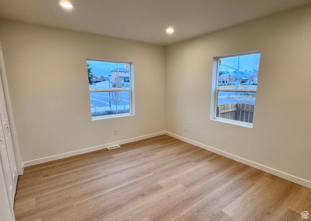 spare room featuring baseboards, recessed lighting, visible vents, and light wood-style floors