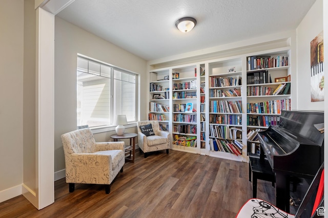 living area featuring a textured ceiling, baseboards, and dark wood-style flooring