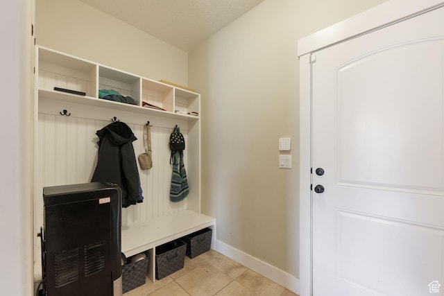 mudroom featuring a textured ceiling, light tile patterned flooring, and baseboards
