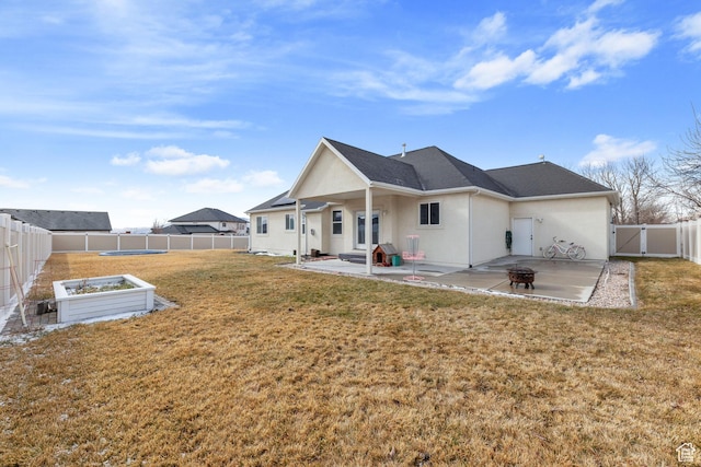 back of house with a patio area, a yard, a fenced backyard, and stucco siding