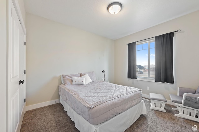 bedroom with baseboards and dark colored carpet