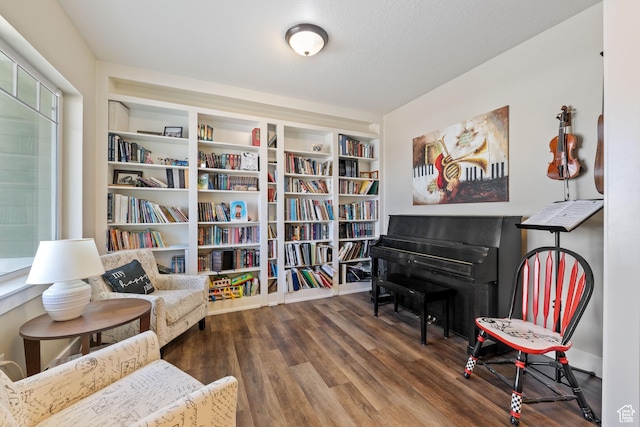 living area with a textured ceiling and wood finished floors