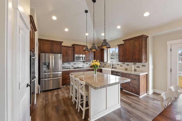 kitchen featuring hanging light fixtures, a kitchen breakfast bar, stainless steel appliances, and a center island