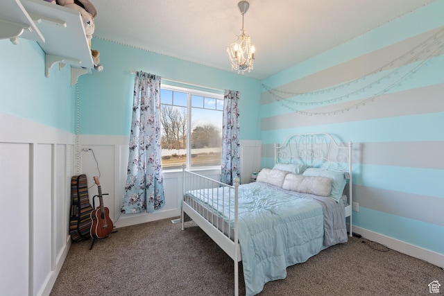 carpeted bedroom with a wainscoted wall and an inviting chandelier