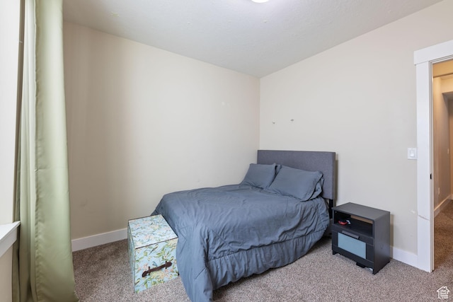 bedroom featuring light carpet and baseboards