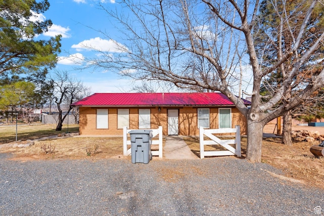 view of front of property with metal roof and brick siding