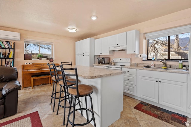 kitchen featuring electric range, light countertops, under cabinet range hood, white cabinetry, and a sink