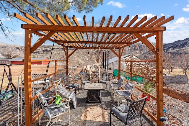 view of patio with an outdoor fire pit, a mountain view, and a pergola