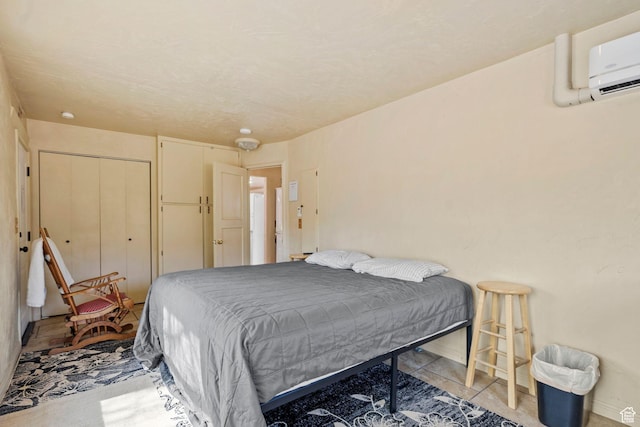 bedroom with a wall unit AC, light tile patterned floors, and a closet