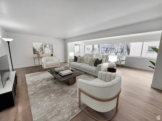 living area with light wood-style floors and baseboards