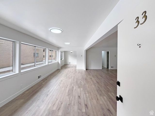 spare room with light wood finished floors, visible vents, and baseboards