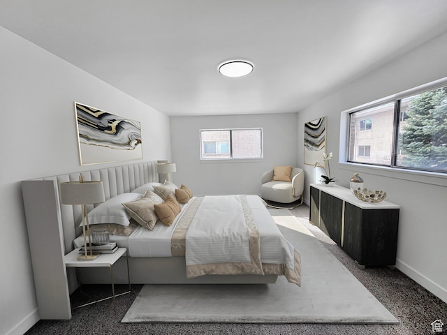 bedroom featuring dark carpet and baseboards