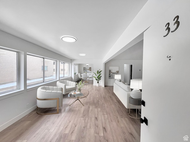 living area with light wood-type flooring and baseboards