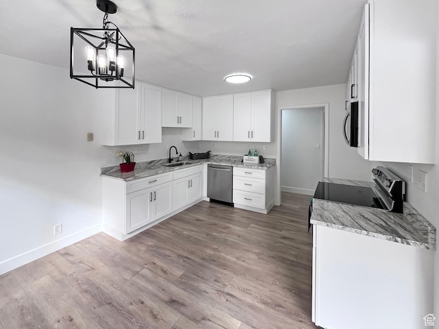 kitchen with light wood-style flooring, stainless steel appliances, a sink, white cabinets, and pendant lighting