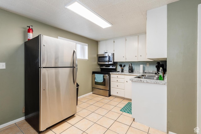 750 N 100 W, Logan, UT 84321 - kitchen featuring stainless steel appliances, light countertops, white cabinets, a sink, and light tile patterned floors