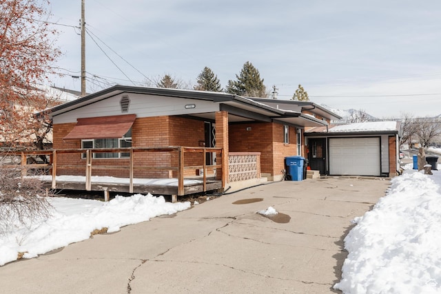view of front of home with a garage, concrete driveway, and brick siding