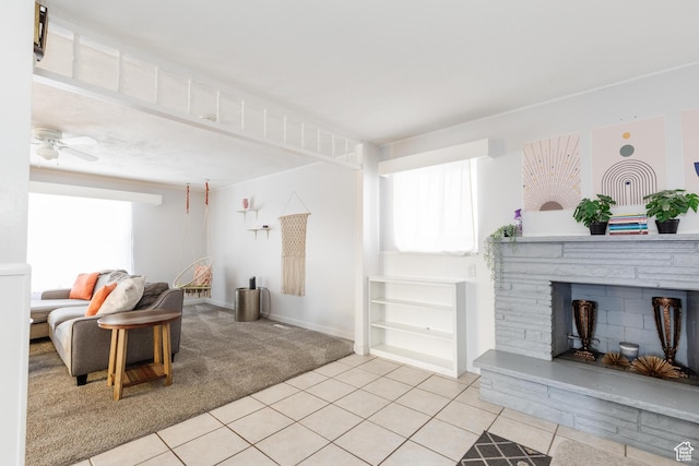 750 N 100 W, Logan, UT 84321 - living room featuring light carpet, light tile patterned flooring, a stone fireplace, a ceiling fan, and baseboards