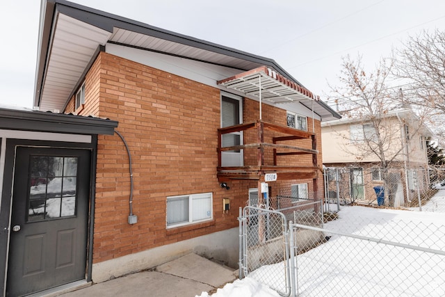 750 N 100 W, Logan, UT 84321 - view of snow covered exterior featuring a gate, fence, brick siding, and a balcony