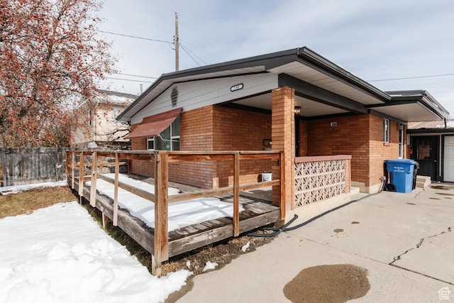 750 N 100 W, Logan, UT 84321 - view of snow covered exterior featuring brick siding, fence, and a porch