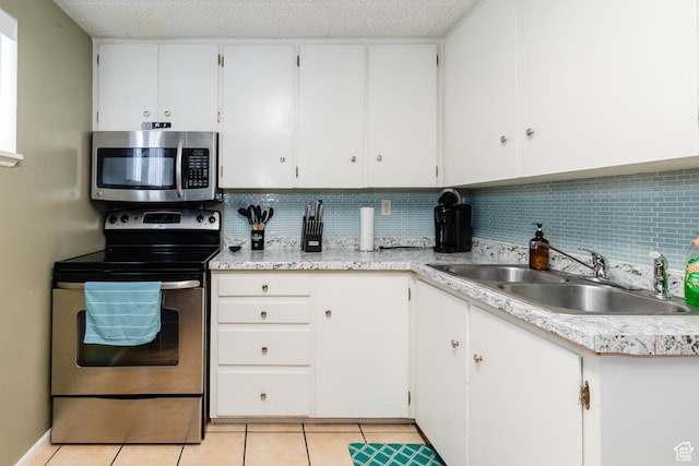 750 N 100 W, Logan, UT 84321 - kitchen with appliances with stainless steel finishes, a sink, light countertops, decorative backsplash, and white cabinets