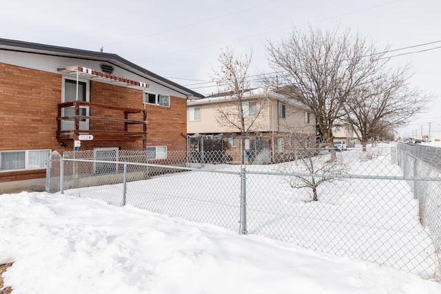 750 N 100 W, Logan, UT 84321 - view of snow covered exterior featuring fence, brick siding, and a balcony