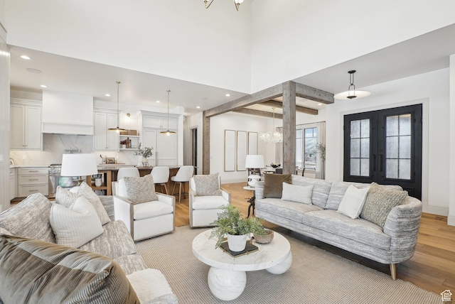 living room featuring light wood finished floors, recessed lighting, and french doors