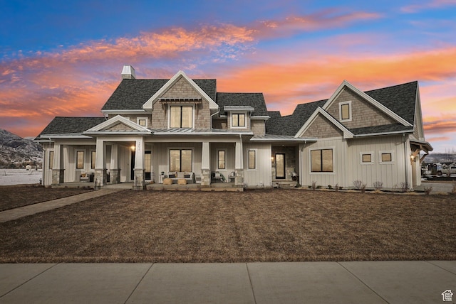 view of front of house featuring a porch, a shingled roof, board and batten siding, a standing seam roof, and metal roof