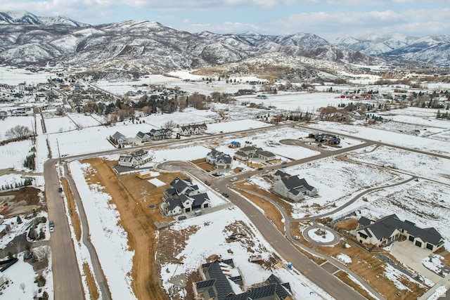 snowy aerial view featuring a residential view and a mountain view