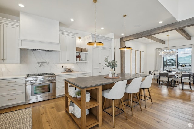 kitchen featuring high end stainless steel range, a kitchen island, and white cabinetry