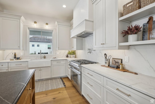 kitchen featuring high end stainless steel range oven, white cabinetry, and open shelves