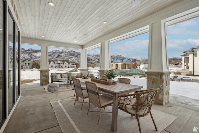 sunroom featuring a wealth of natural light, wooden ceiling, a residential view, and a mountain view