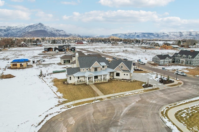 snowy aerial view with a residential view and a mountain view