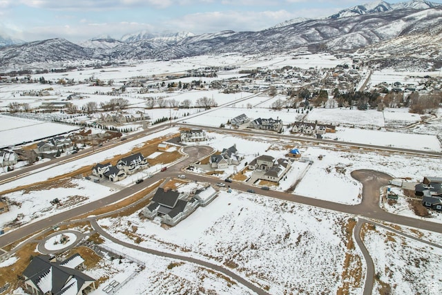 snowy aerial view with a residential view and a mountain view