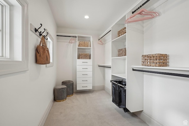 walk in closet featuring light colored carpet