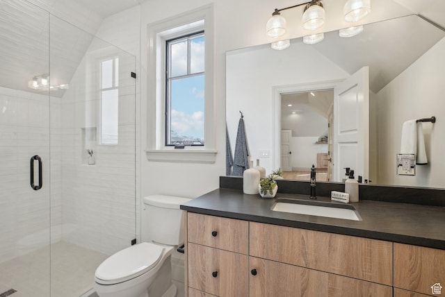 bathroom featuring toilet, a stall shower, lofted ceiling, and vanity