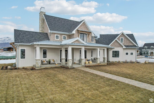 view of front of home featuring covered porch, a front lawn, and board and batten siding
