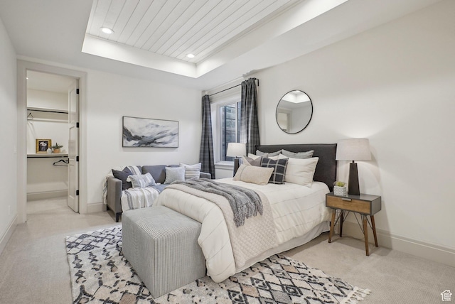 bedroom with baseboards, a tray ceiling, recessed lighting, and light colored carpet