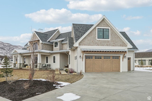 shingle-style home featuring concrete driveway, board and batten siding, a standing seam roof, metal roof, and a garage