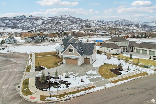 snowy aerial view featuring a residential view and a mountain view