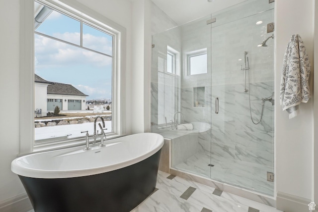 bathroom featuring marble finish floor, a marble finish shower, and a freestanding bath