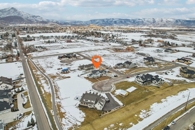 snowy aerial view with a residential view and a mountain view
