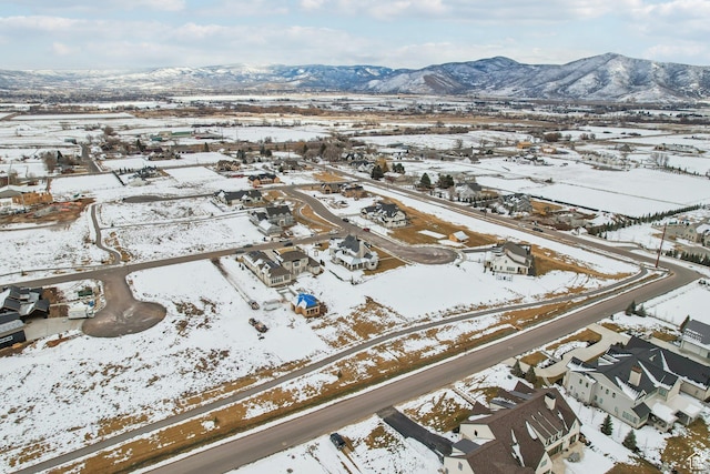 snowy aerial view with a residential view and a mountain view