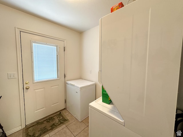 laundry room featuring stacked washer and dryer, laundry area, and light tile patterned floors