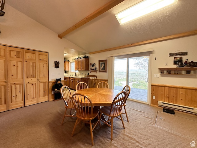 dining area featuring a wainscoted wall, vaulted ceiling with beams, light carpet, and baseboard heating